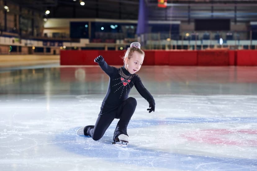 a young girl skating on an ice rink